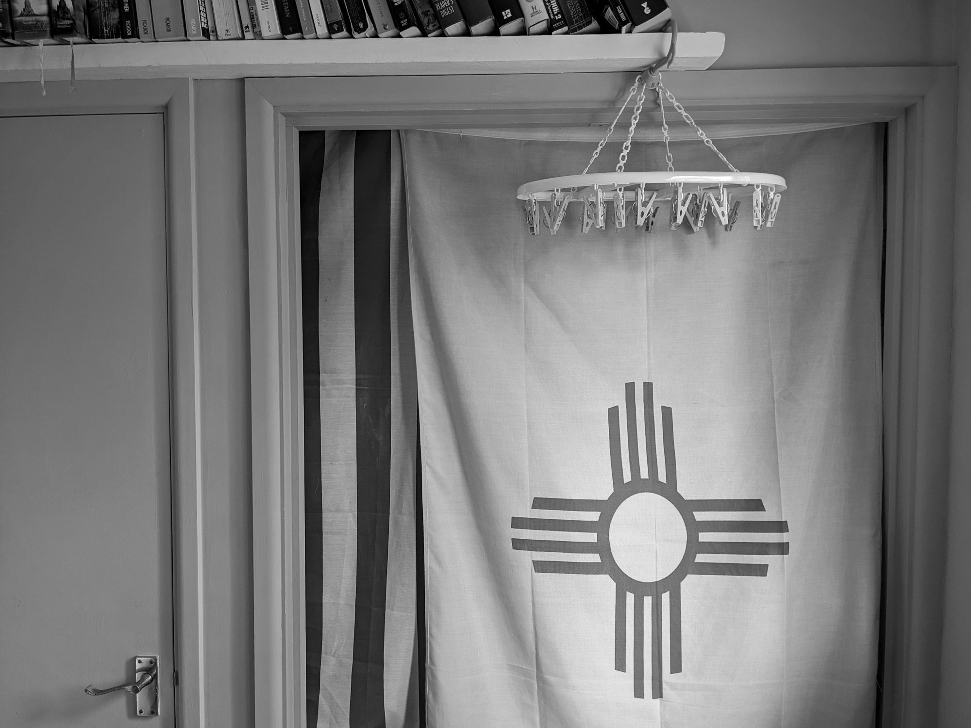 A sock dryer hanging over a New Mexico flag