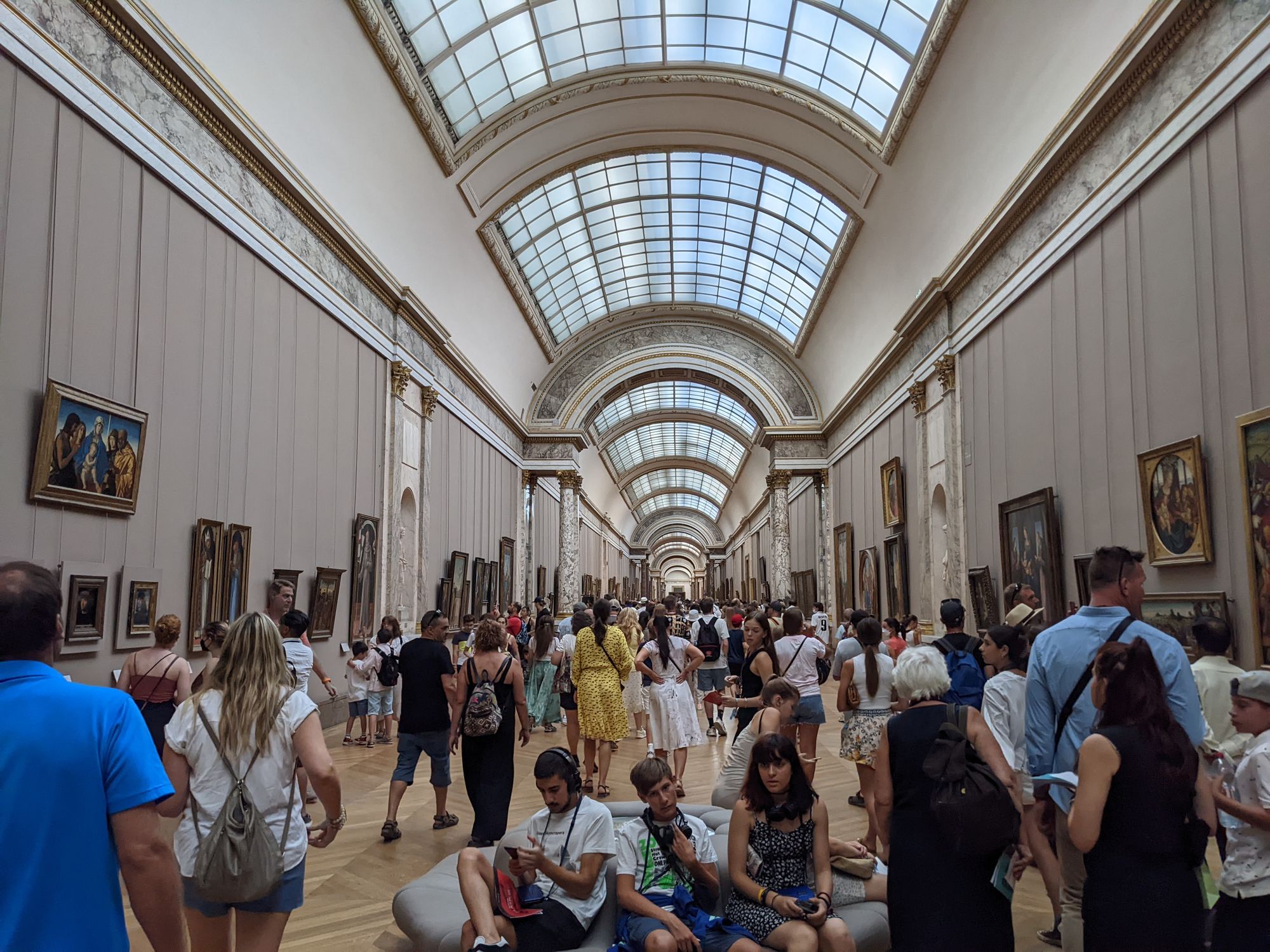 Crowds of people in a corridor of the Louvre Museum in Paris