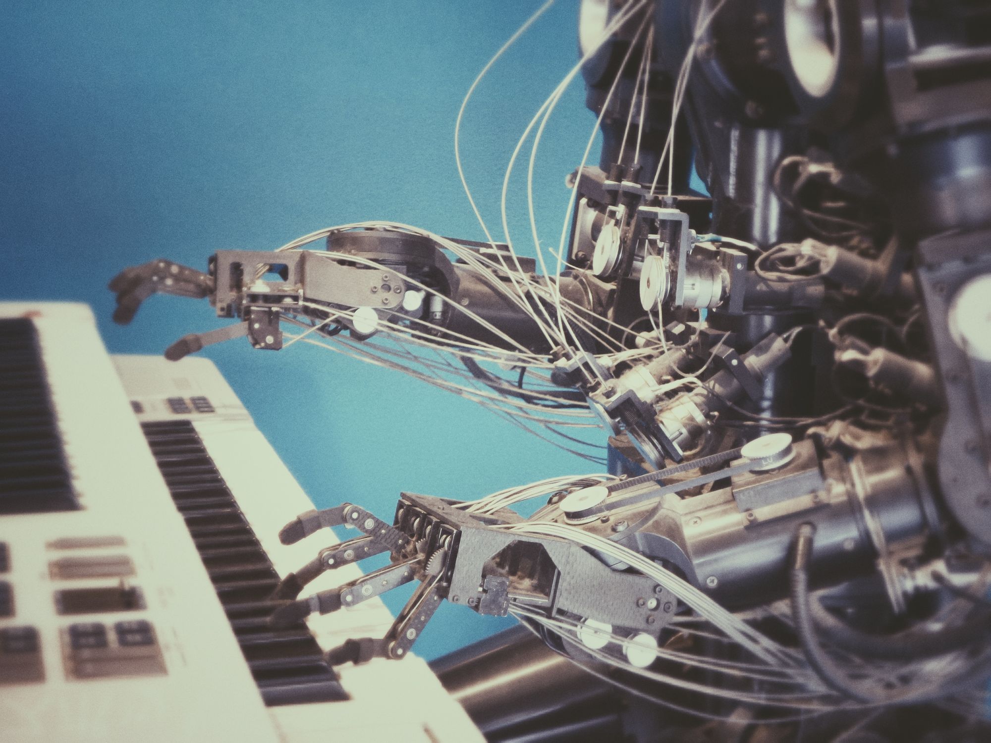 A robot plays a keyboard piano signifying artificial intelligence